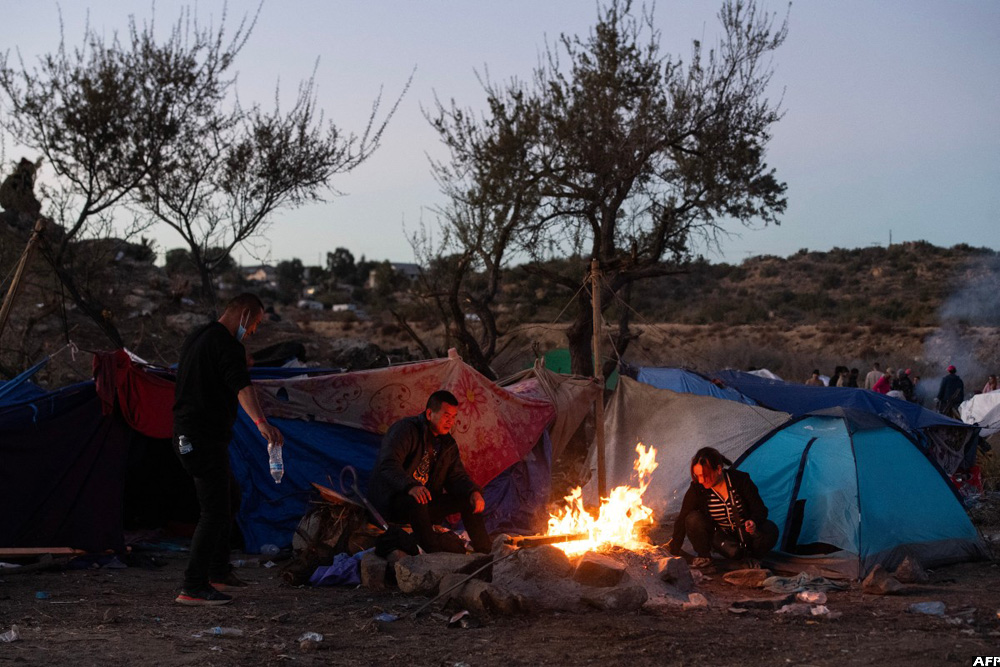 Migrants huddle in open-air camps on US border